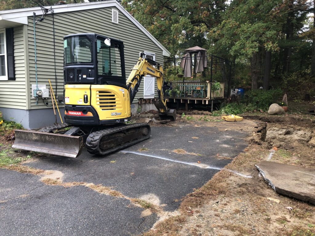 Mini excavator digging for a house addition in Bellingham, MA