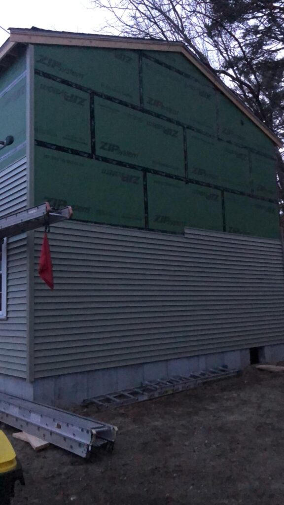Sheathed addition next to the existing house in Bellingham, MA