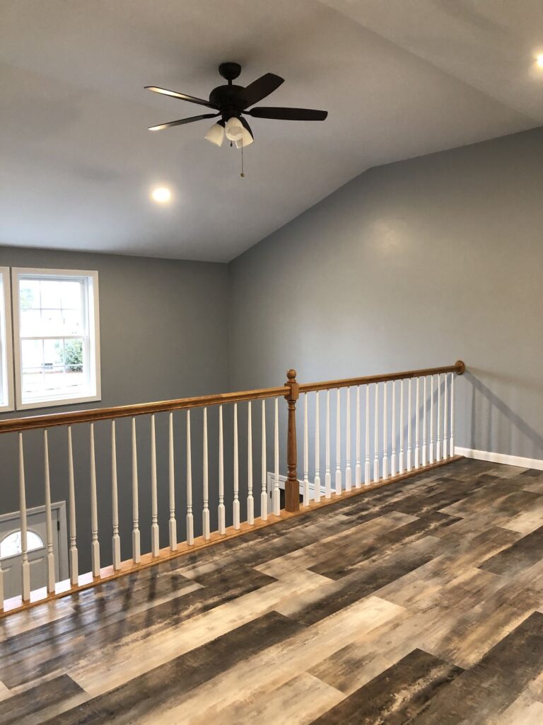 Upstairs loft with ceiling fan and wood-look floors in Bellingham, MA