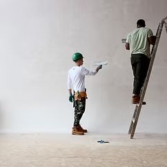 Plasterers finishing a wall and ceiling